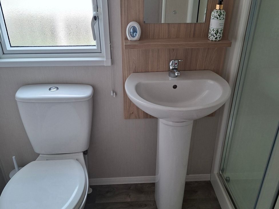 A bathroom with a sink and toilet at Primrose Valley, Amara's Retreat in Filey
