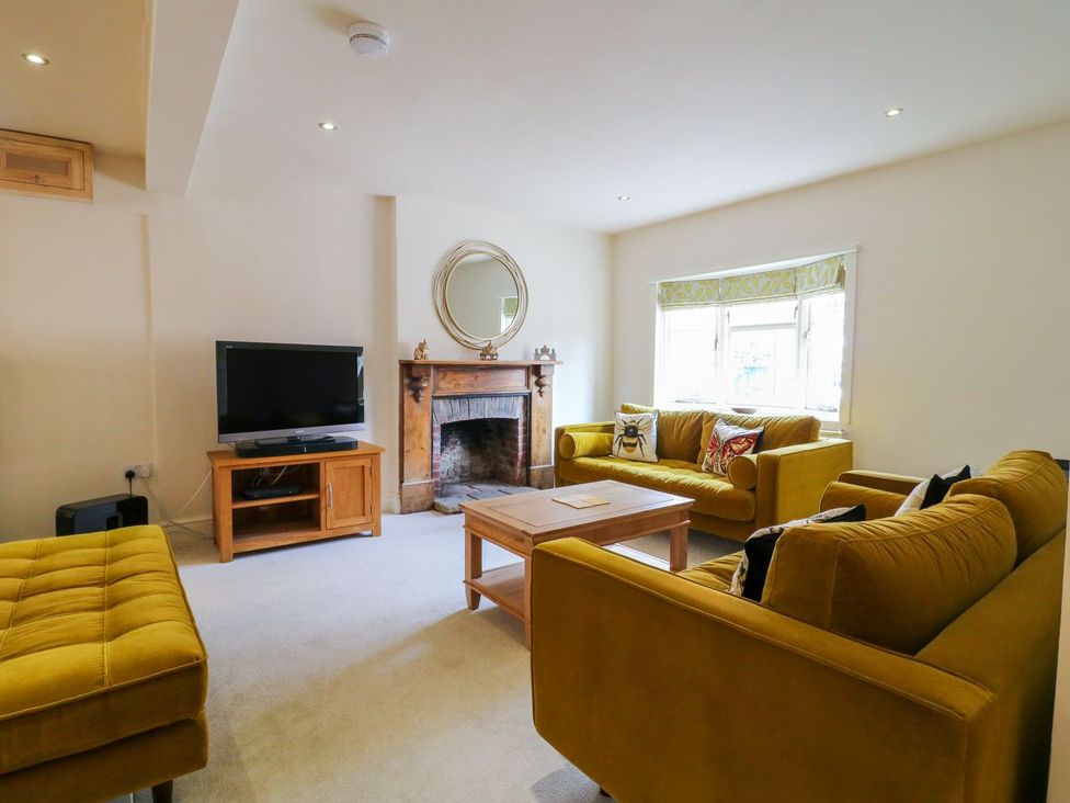 A living room with a television and a fireplace at Lion House in Ashbourne