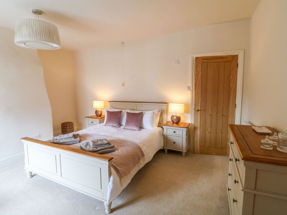 A bedroom with a bed and nightstand at Lion House in Ashbourne