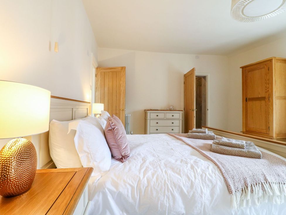 A bedroom with a bed, lamp, and wardrobe at Lion House in Ashbourne