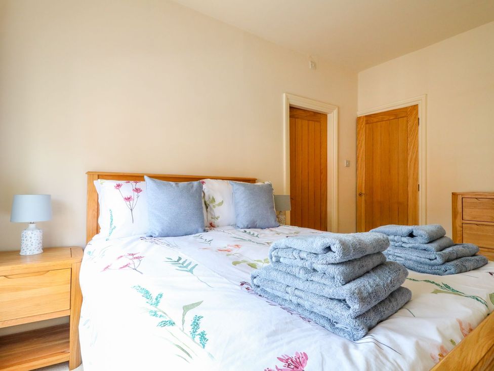 A bedroom with a bed and towels stacked on it at Lion House in Ashbourne