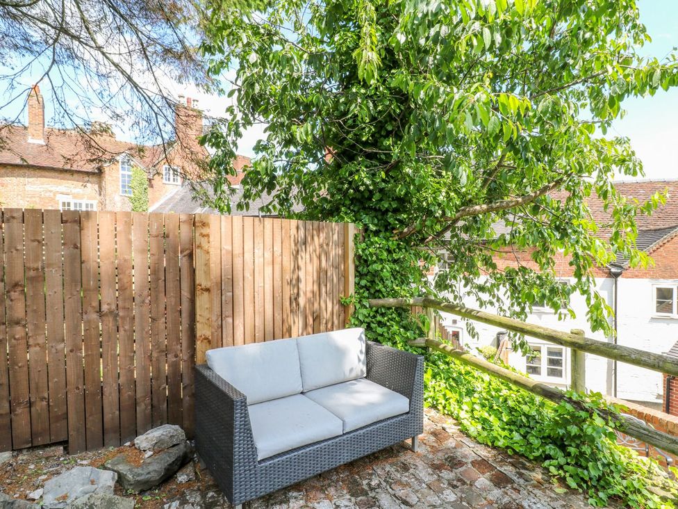 A sofa with a fence and tree in an outdoor area at Lion House Ashbourne