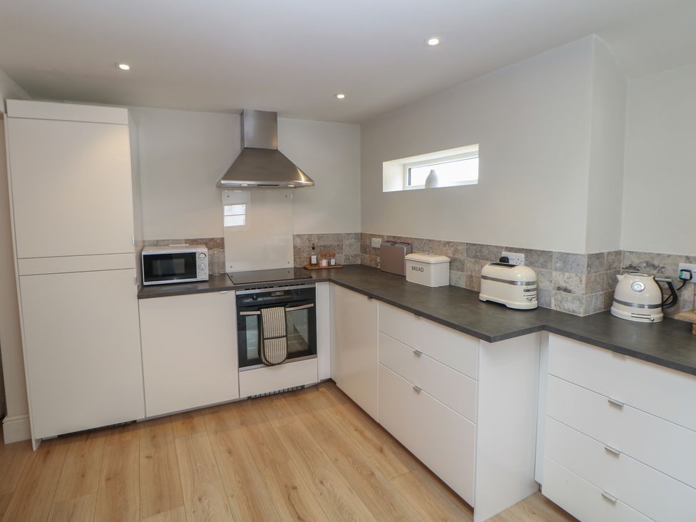 A kitchen with cabinets, microwave, and oven at Lion House in Ashbourne