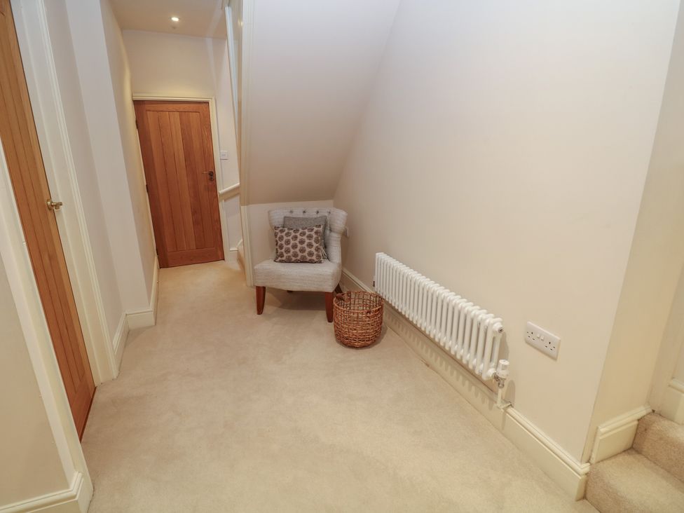 A hallway with a chair and door at Lion House in Ashbourne