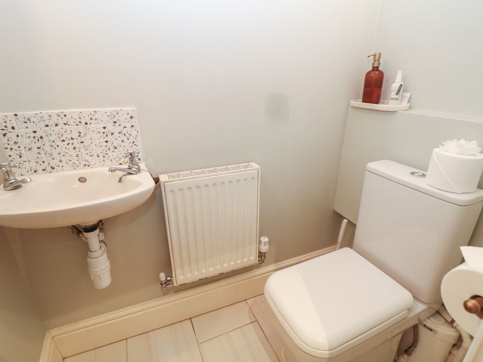A bathroom with a toilet, sink, and radiator at Lion House in Ashbourne