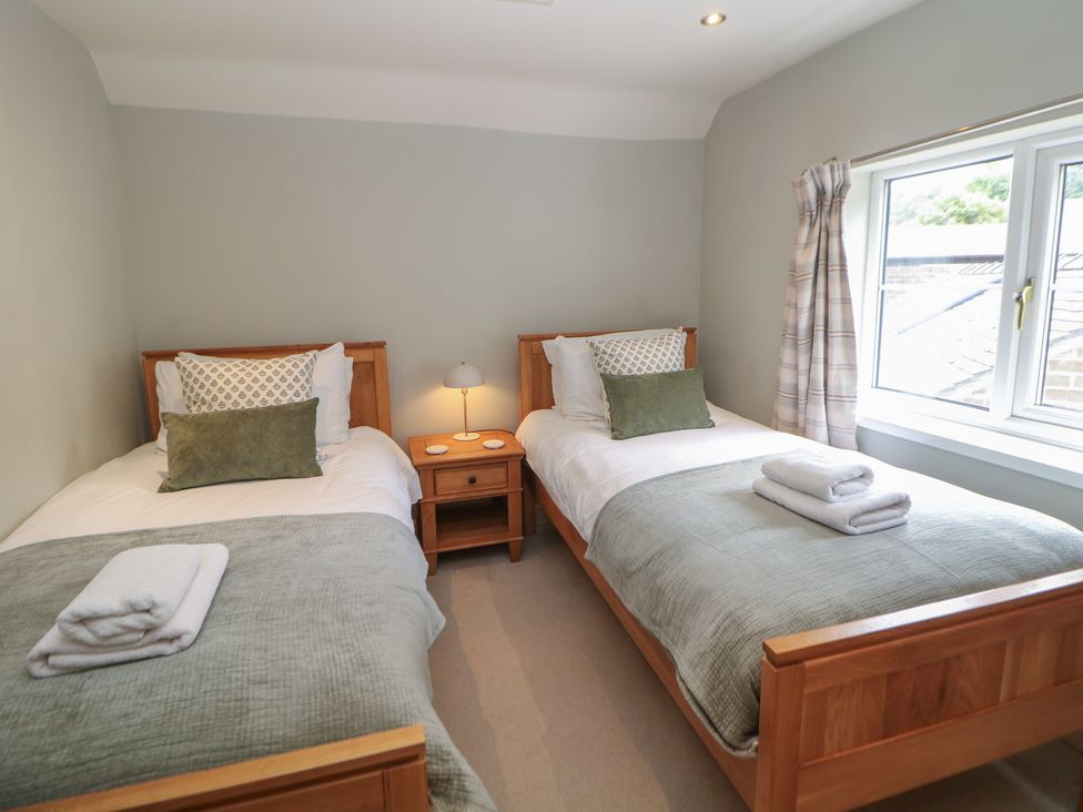 A bedroom with two beds and a nightstand at Lion House in Ashbourne