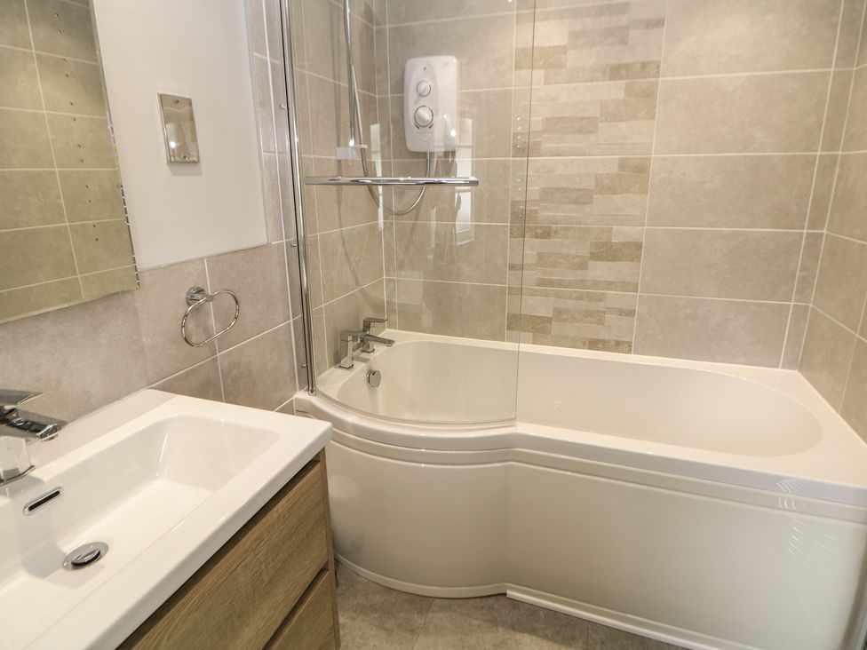 A bathroom with a bathtub, shower, and sink at Lion House in Ashbourne