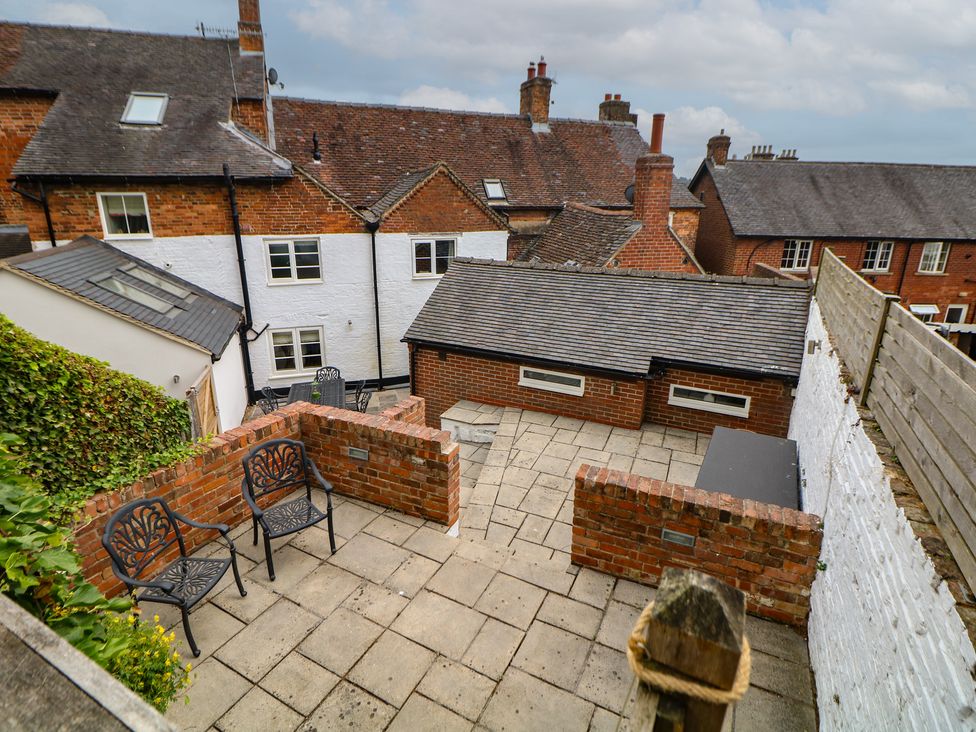 An outdoor area with a paved patio and chairs at Lion House in Ashbourne