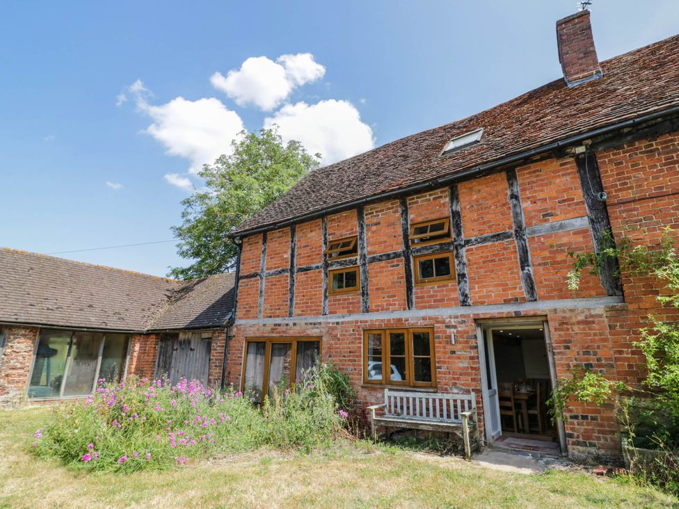 A house with a garden and bench at Netherend Barn in Colwall Green near Great Malvern