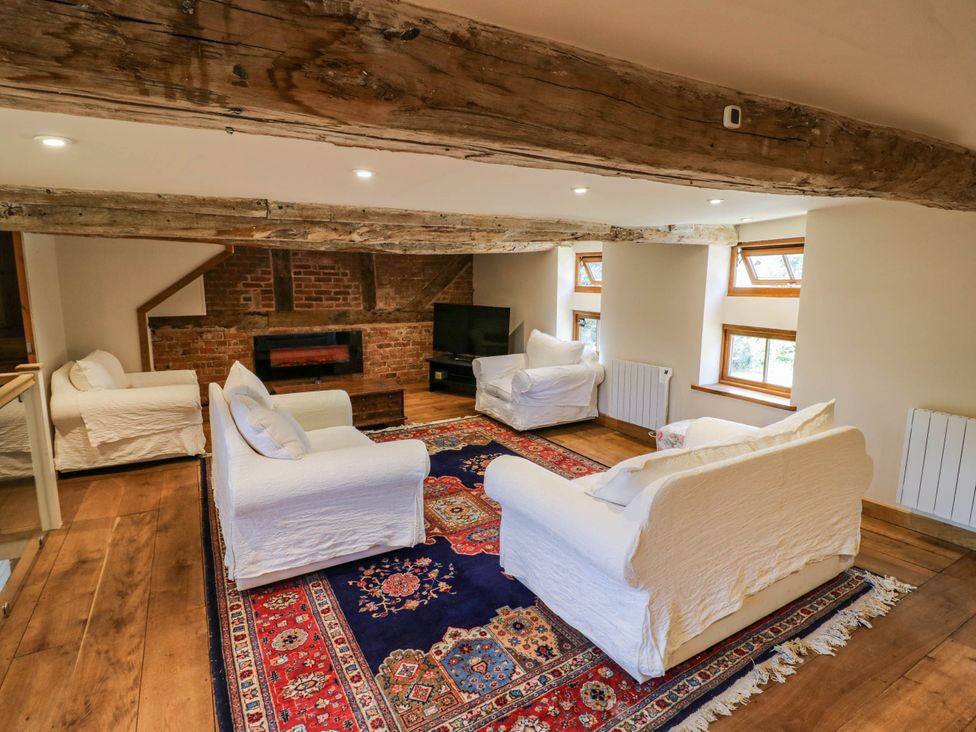 A living room with seating and a television at Netherend Barn in Colwall Green near Great Malvern