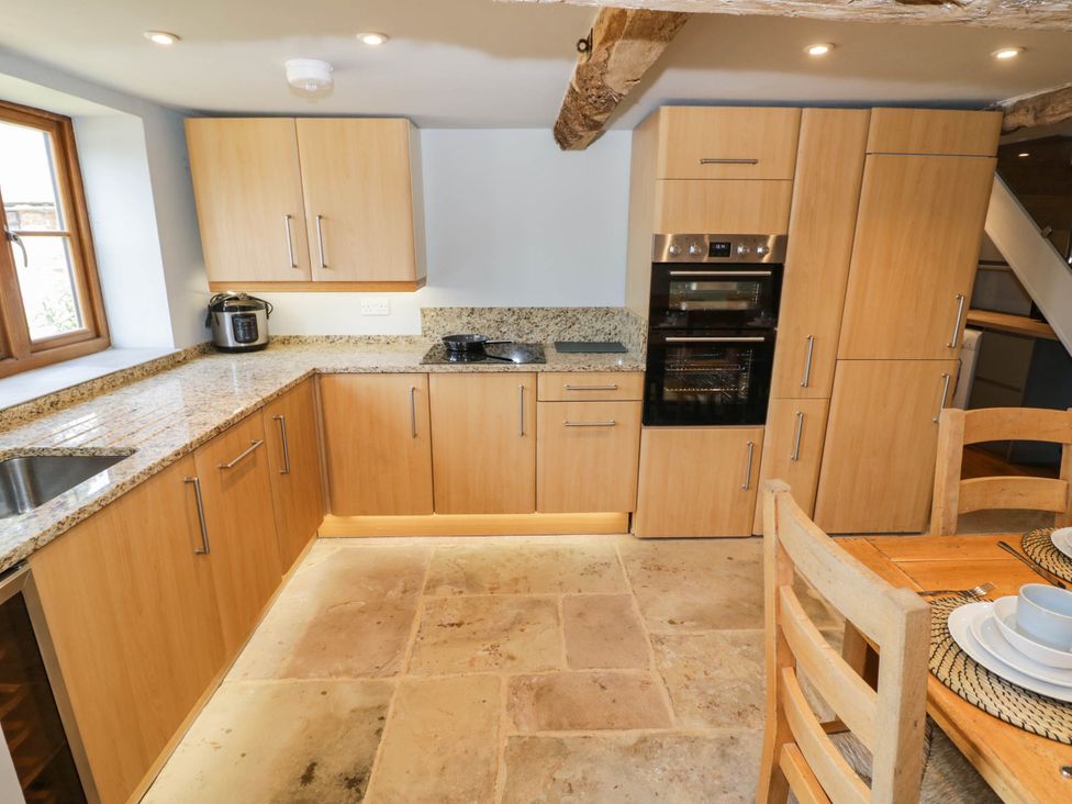 A kitchen with wood cabinets and appliances at Netherend Barn Colwall Green near Great Malvern