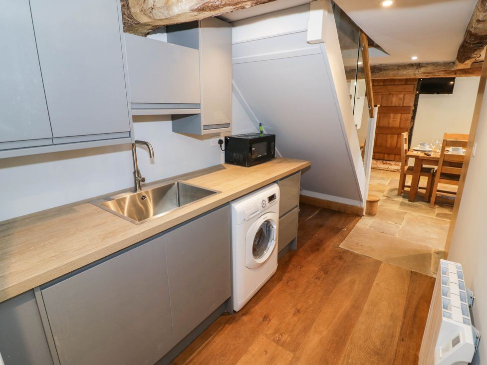 A kitchen with a sink and washing machine at Netherend Barn Colwall Green near Great Malvern