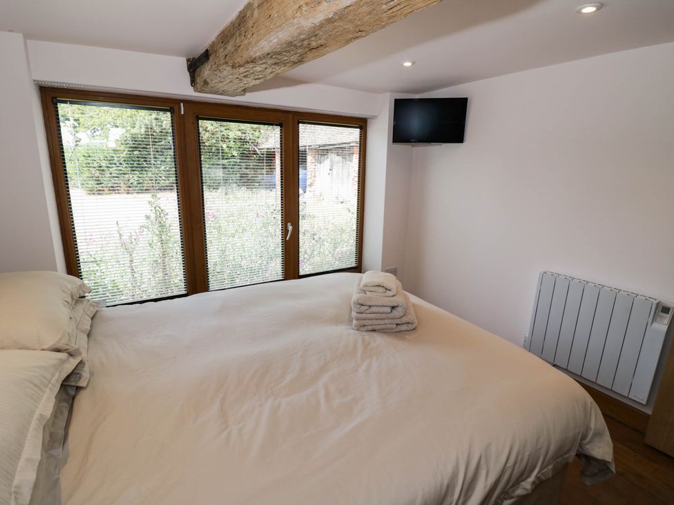 A bedroom with a bed and towels on the bed at Netherend Barn in Colwall Green near Great Malvern