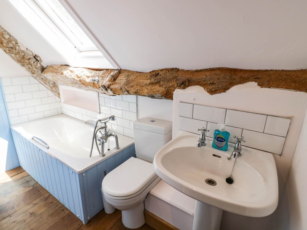 A bathroom with a bathtub, toilet, and sink at Netherend Barn in Colwall Green near Great Malvern