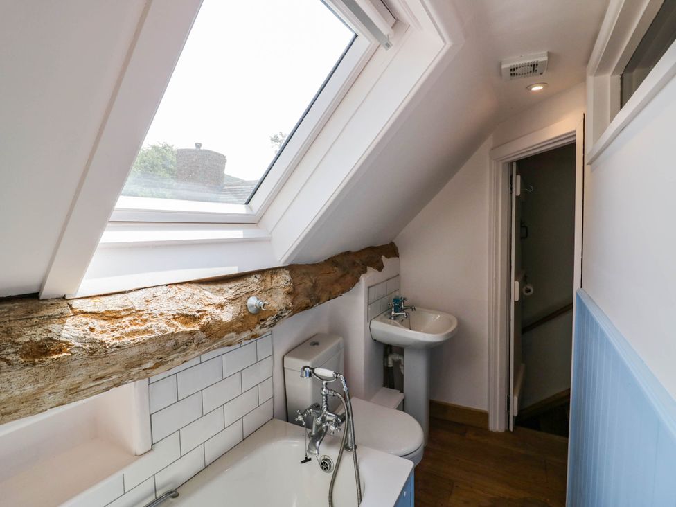 A bathroom with a bathtub, sink and toilet at Netherend Barn, Colwall Green near Great Malvern