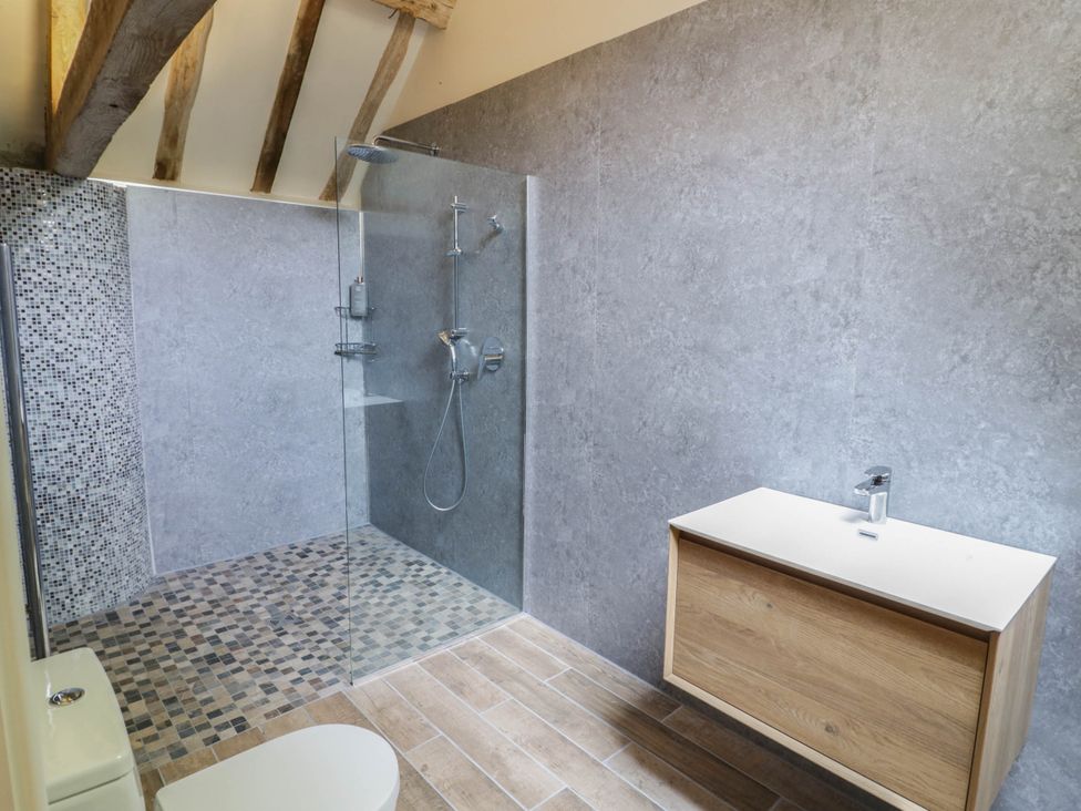 A bathroom with a shower, sink, and toilet at Netherend Barn, Colwall Green near Great Malvern