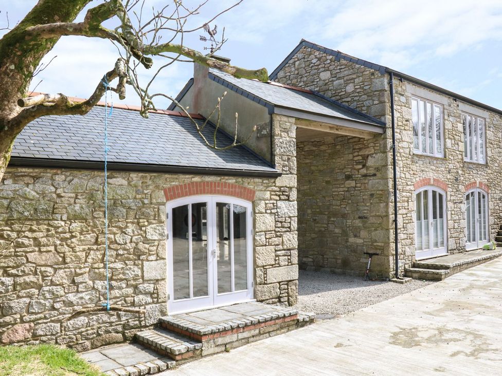 An exterior view of a stone house with windows and a patio at Dexter in Treverva near Constantine