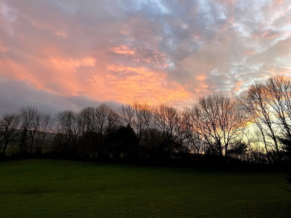 A landscape view with trees and a colorful sky at The White House Okehampton