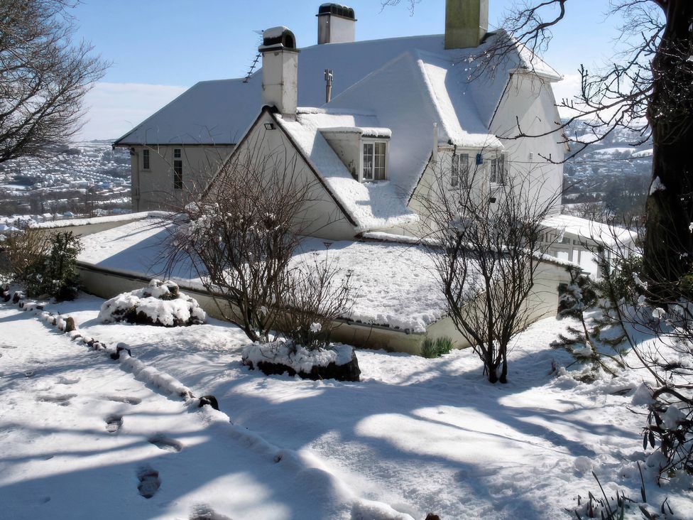 A house covered in snow with a garden at The White House in Okehampton