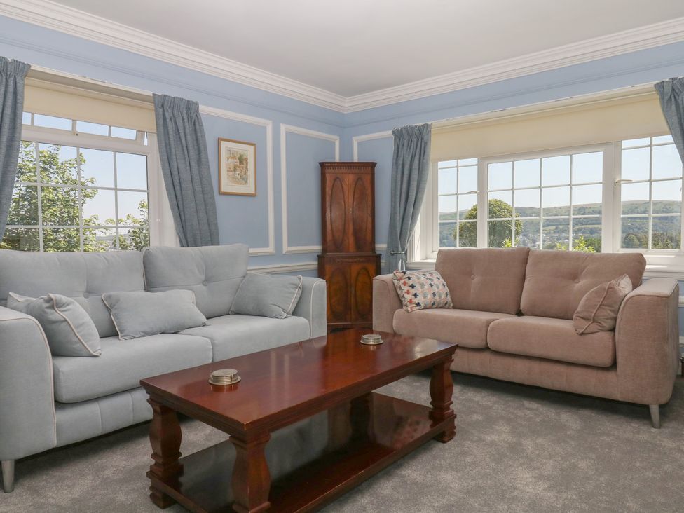A living room with a blue sofa and a coffee table at The White House in Okehampton