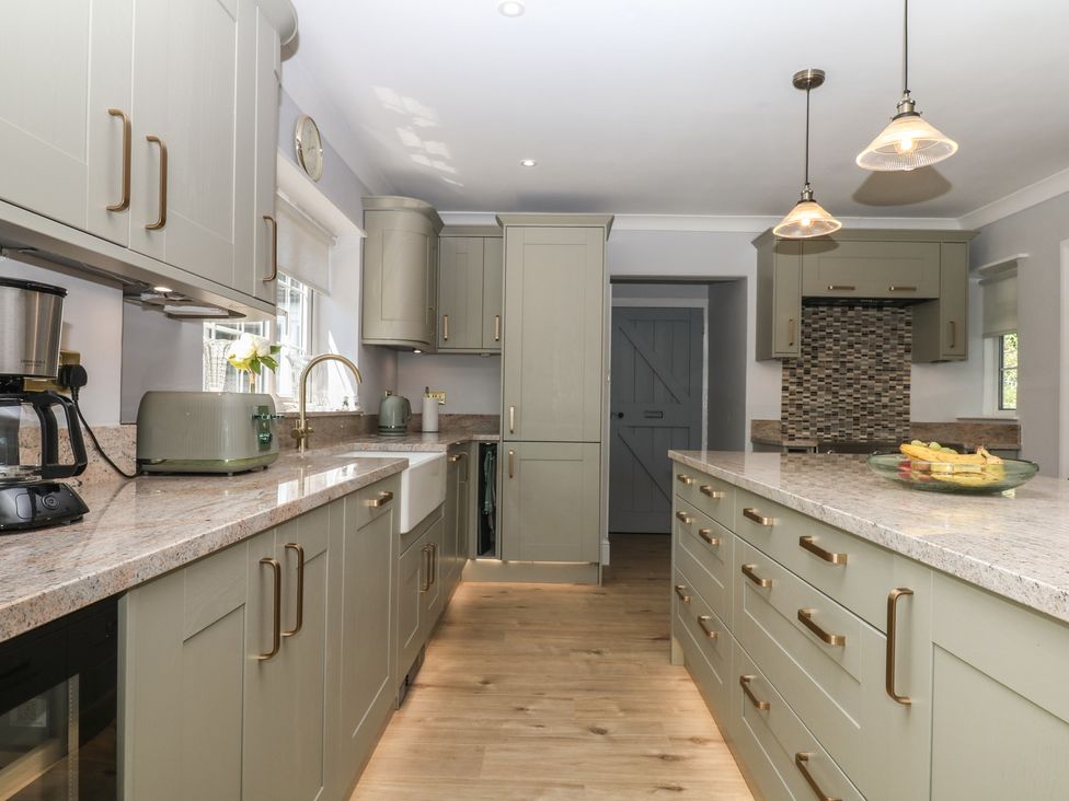 A kitchen with cabinets and a sink at The White House in Okehampton