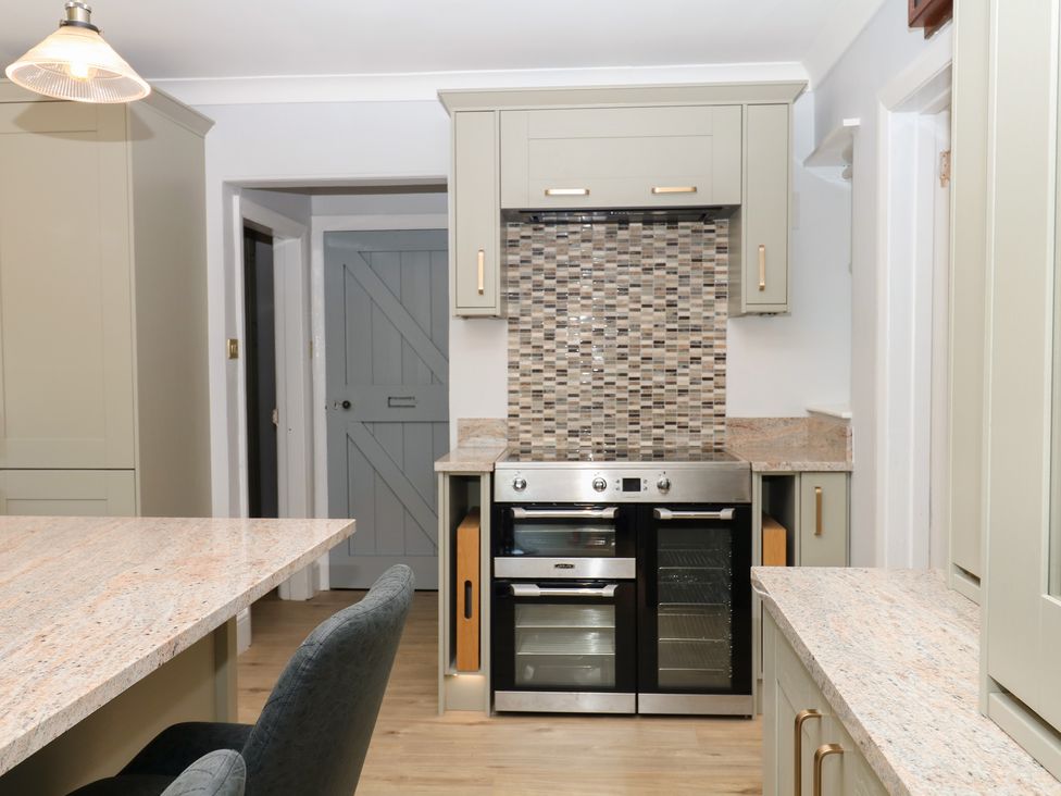 A kitchen with an oven and cabinets at The White House in Okehampton