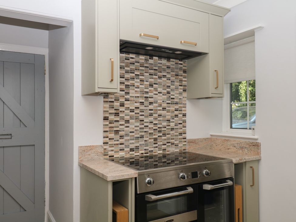 A kitchen with a cooker and cabinet at The White House in Okehampton