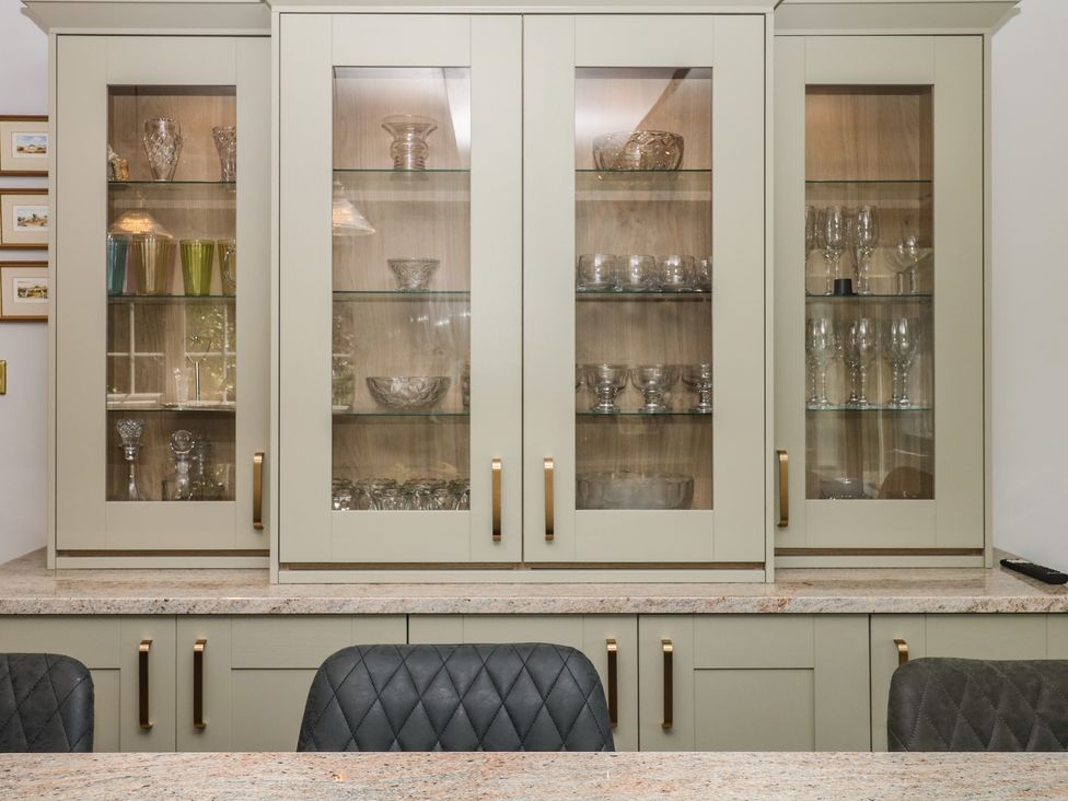 A glass cabinet with crystal items and glasses at The White House Okehampton