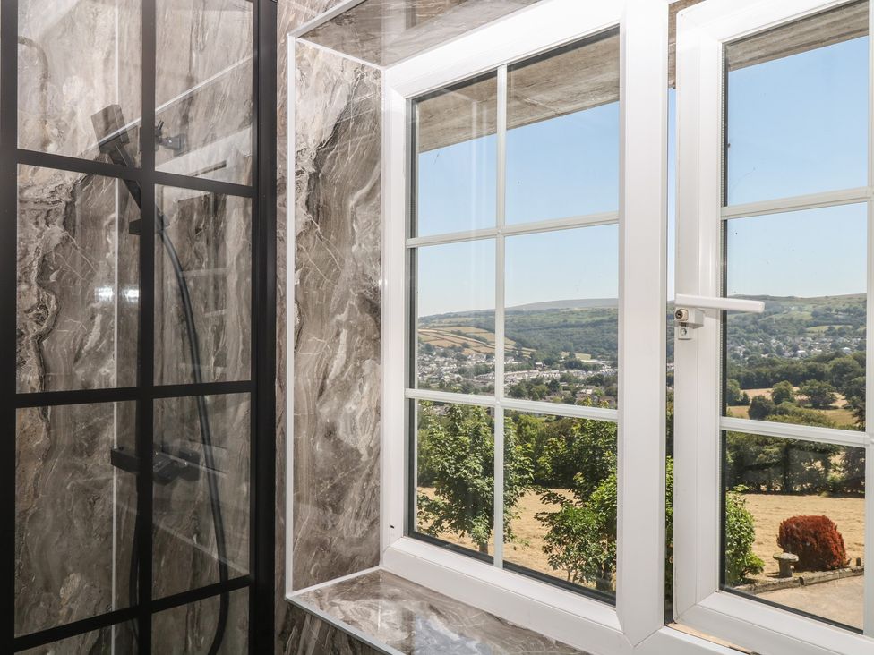 A bathroom with a window showing a landscape at The White House in Okehampton