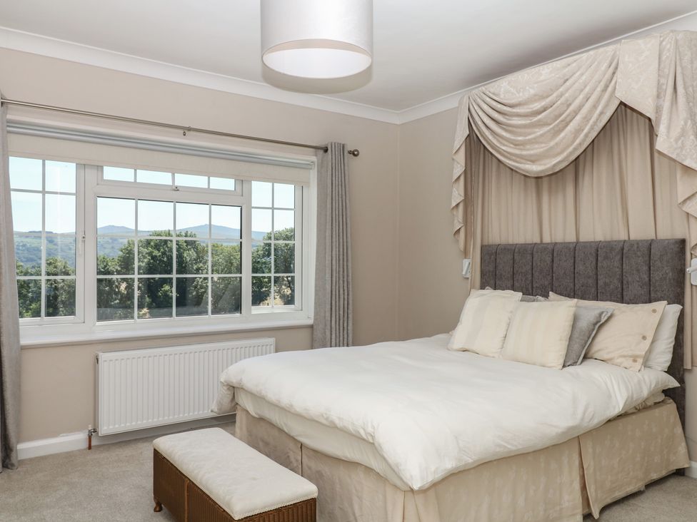 A bedroom with a bed and large window at The White House in Okehampton