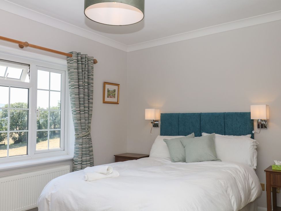 A bedroom with a bed and window at The White House in Okehampton