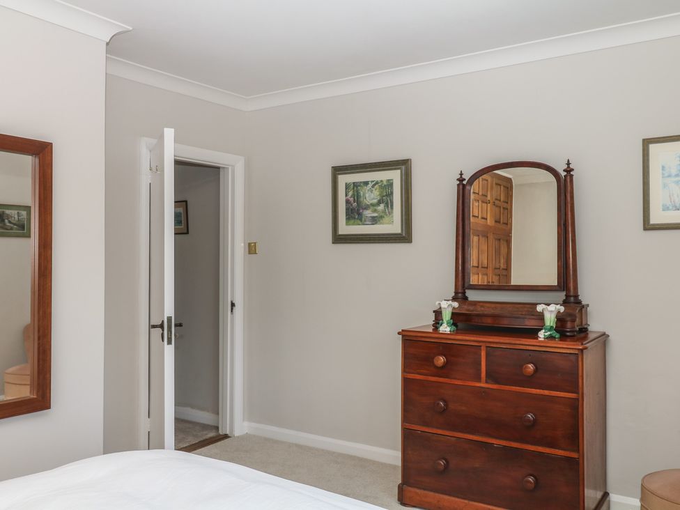 A bedroom with a dresser and mirror at The White House Okehampton