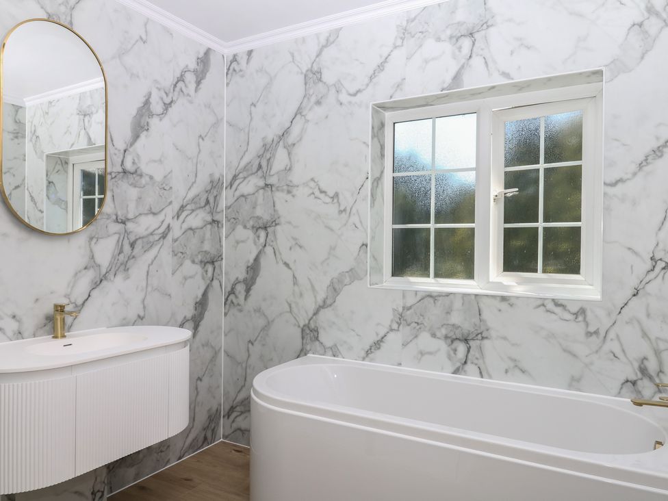 A bathroom with a bathtub and sink at The White House in Okehampton