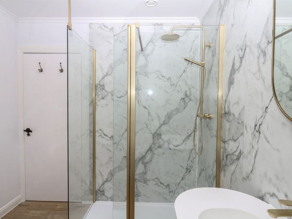 A bathroom with a shower and marble walls at The White House in Okehampton