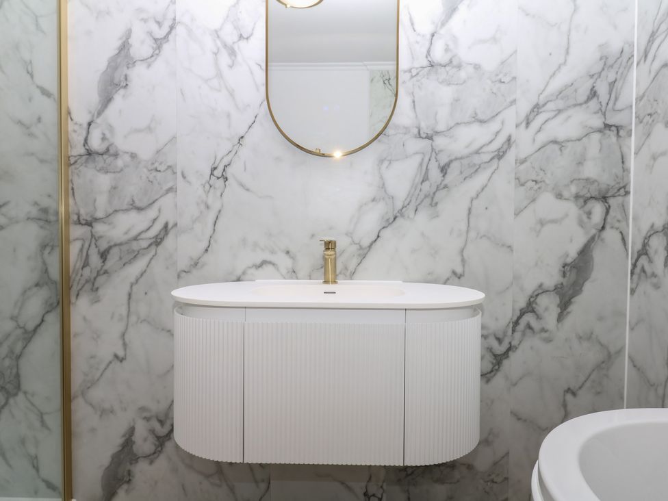 A bathroom with a vanity and a mirror at The White House in Okehampton