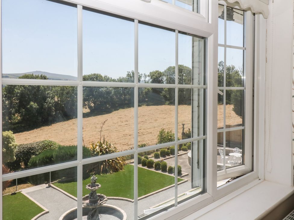 A view from a window showing a garden and fields at The White House in Okehampton