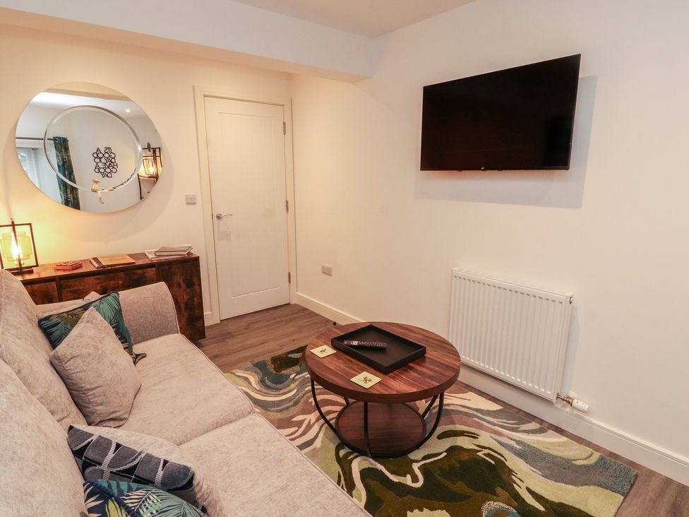 A living room with a sofa, coffee table, and television at Hidden Gem