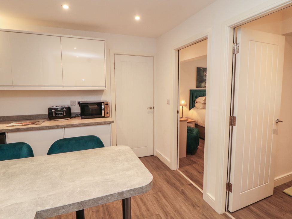 A kitchen with appliances and dining table at Hidden Gem 