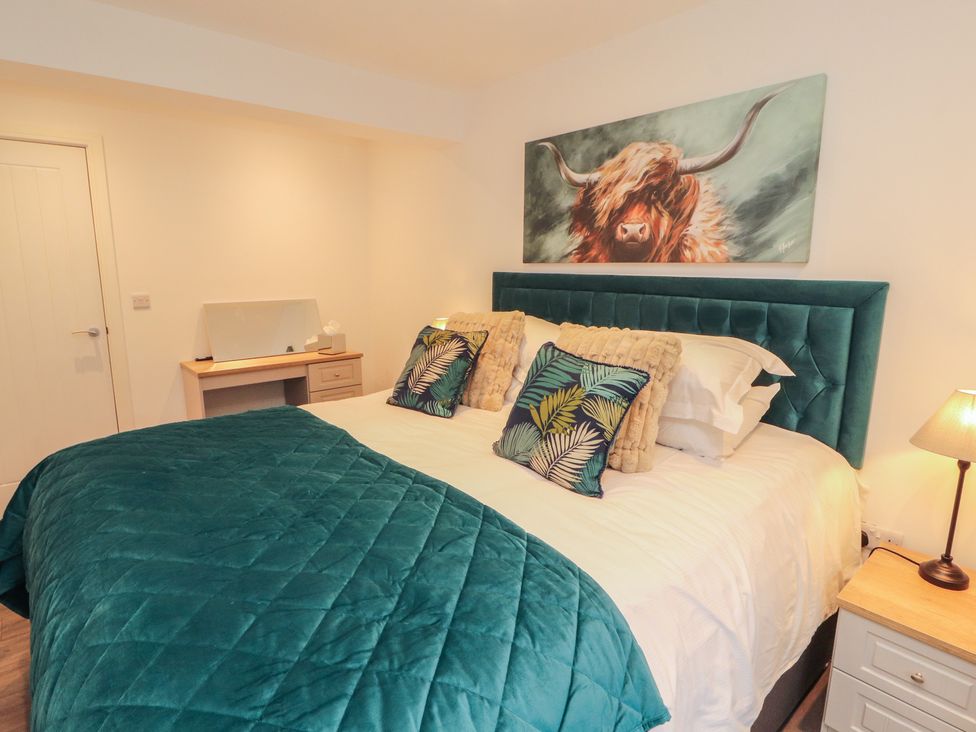 A bedroom with a bed, bedside table and lamp at Hidden Gem