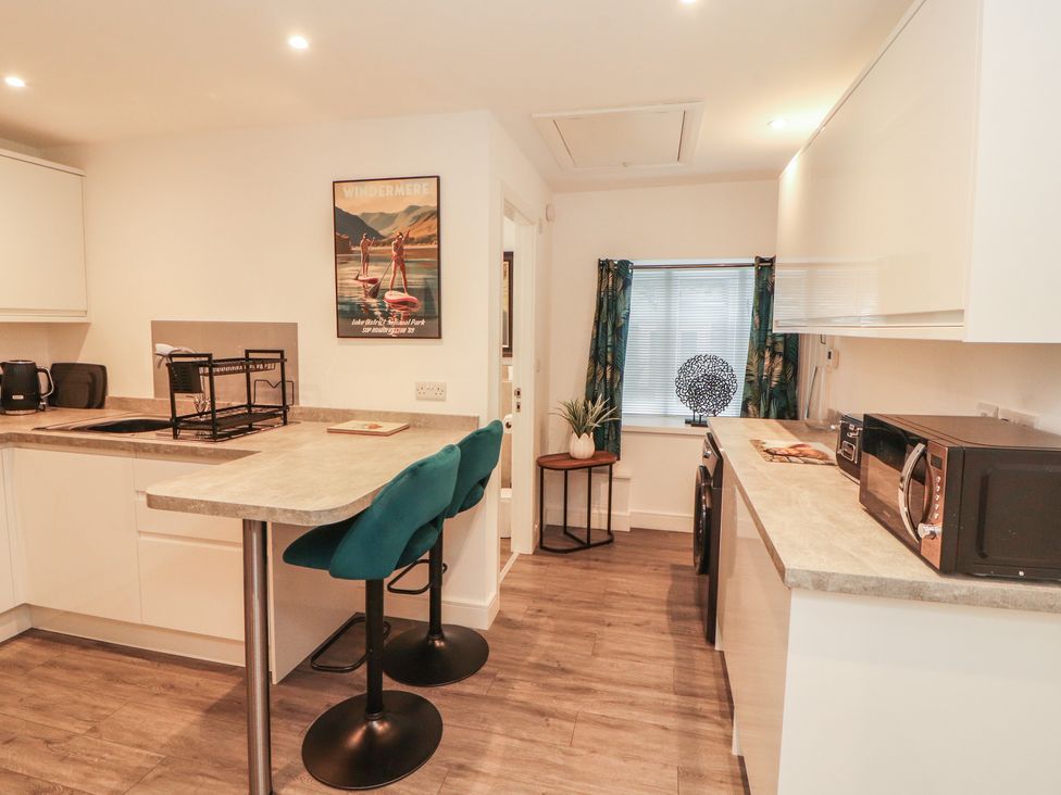 A kitchen with bar stools and appliances at Hidden Gem 