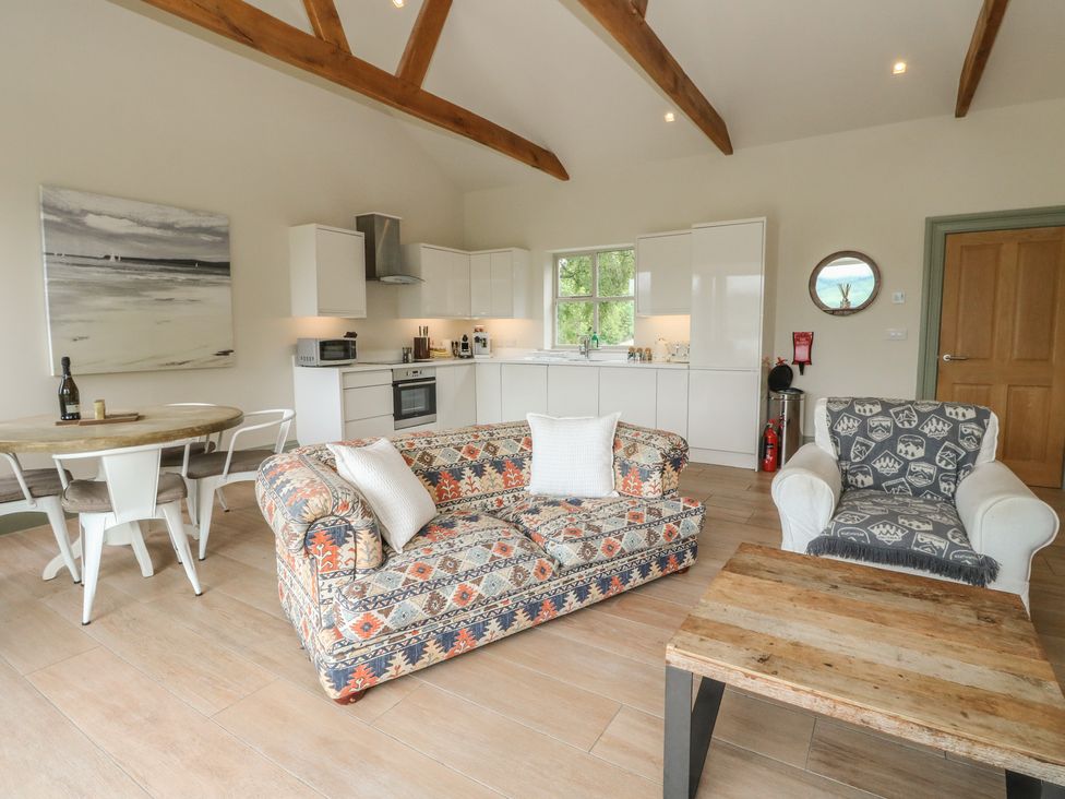A living room with a sofa and armchair at The Tractor Shed in Killin