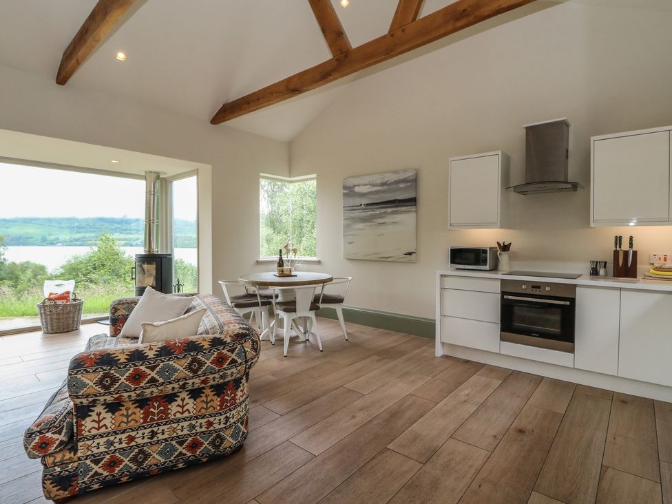 A kitchen with a sofa, table, and chairs at The Tractor Shed in Killin