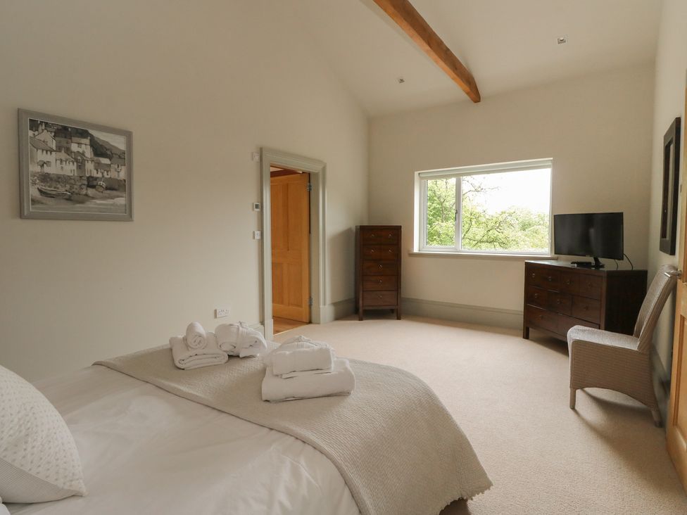 A bedroom with a bed, television, and wardrobe at The Tractor Shed in Killin