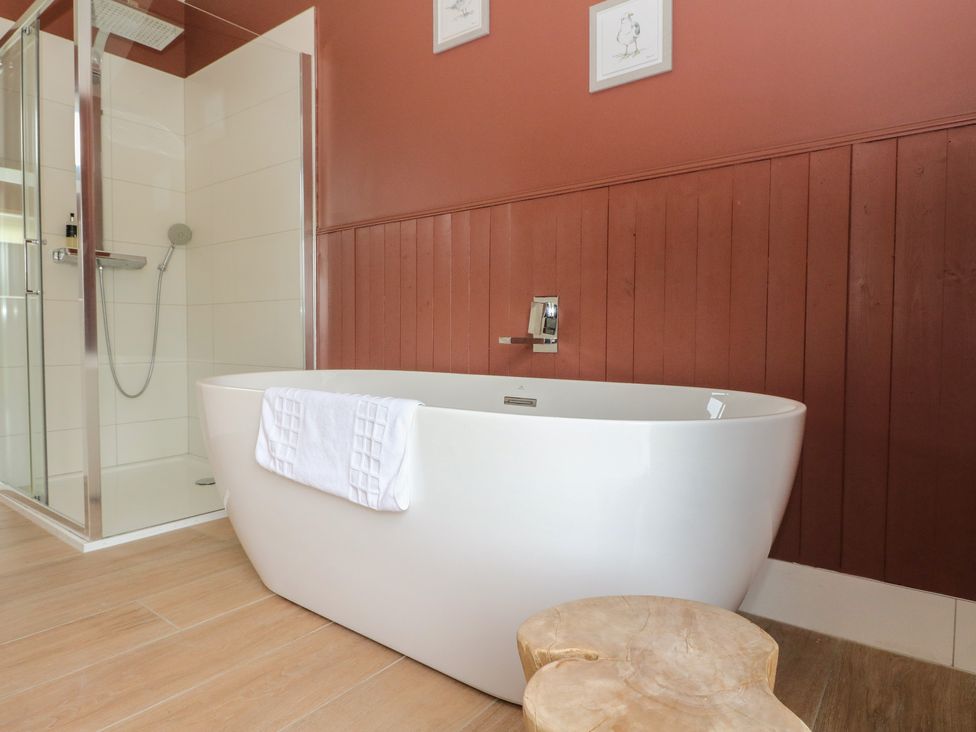 A bathroom with a bathtub and shower at The Tractor Shed in Killin
