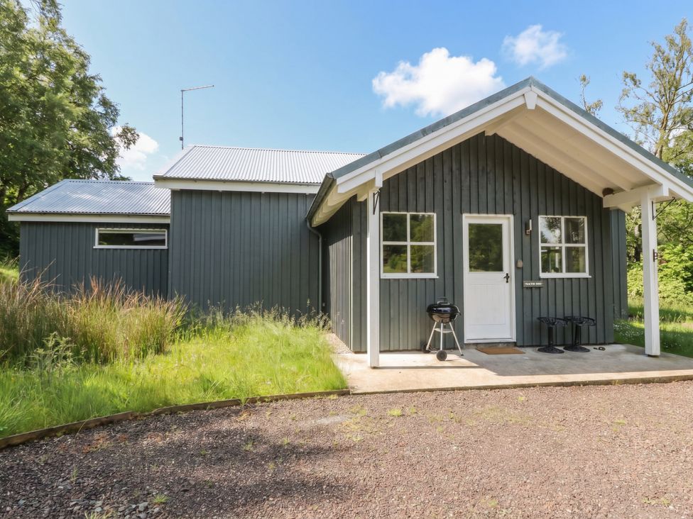 A house with a door and windows in an outdoor area at The Tractor Shed in Killin