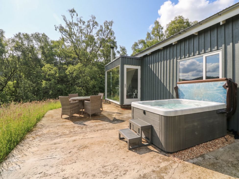 An outdoor area with a hot tub and seating at The Tractor Shed in Killin