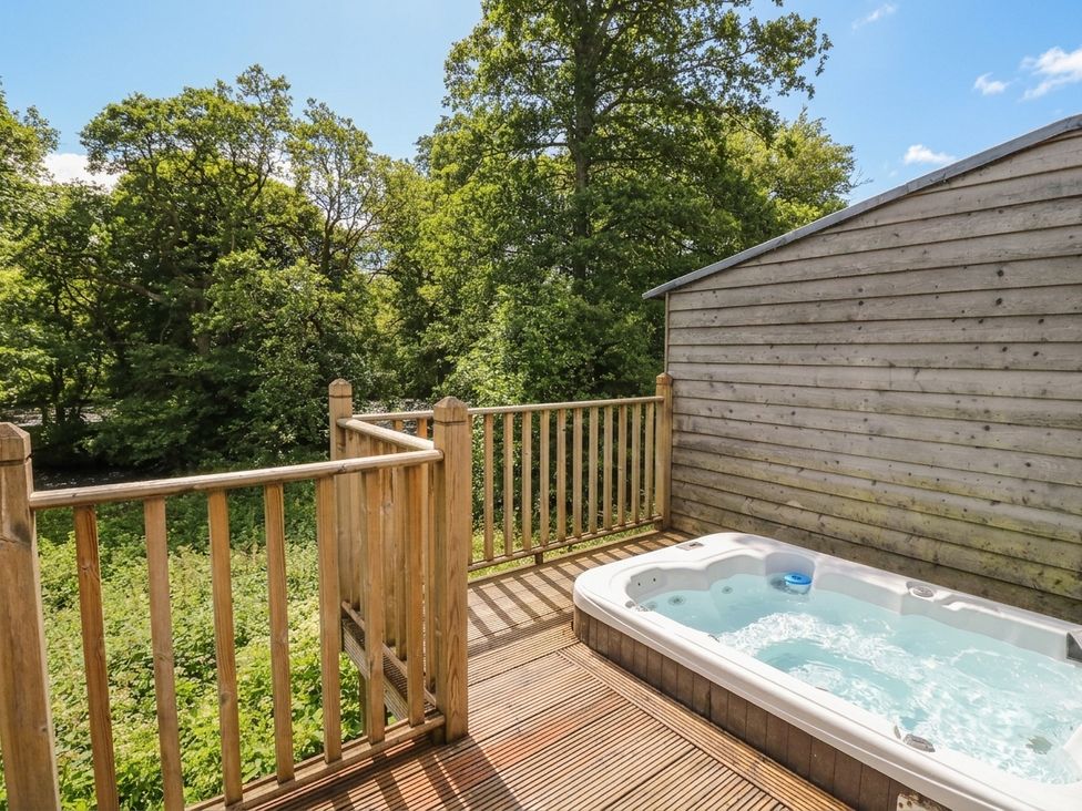 An outdoor space with a hot tub on a wooden deck at Almond in Killin