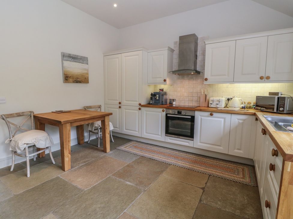 A kitchen with cabinets and a table at Almond in Killin