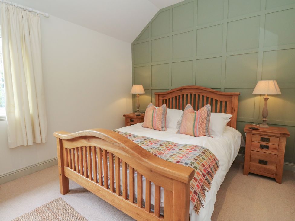 A bedroom with a wooden bed and bedside tables at Almond in Killin