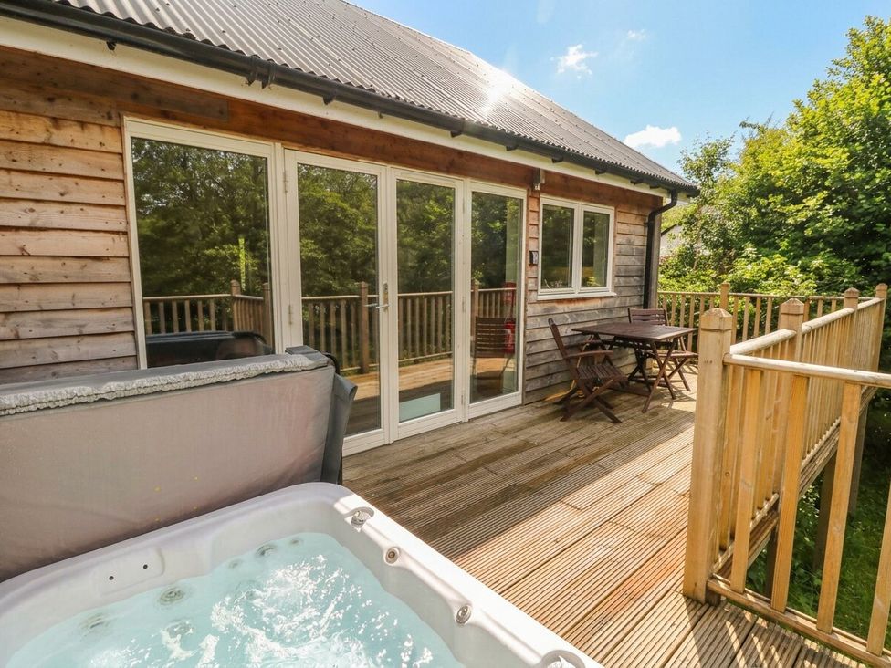 An outdoor area with a hot tub and seating at Garth Cottage in Killin